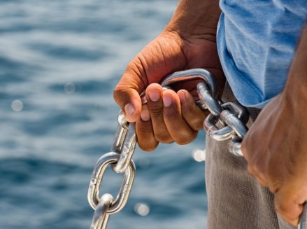 hands holding anchor chain on boat